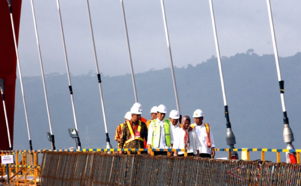 Presiden dan Ibu Negara Gandeng Tangan-Payungan Saat Tinjau Jembatan Holtekamp